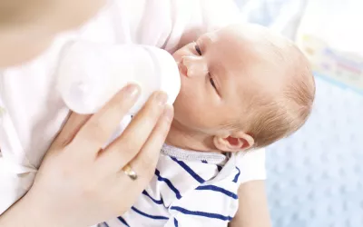 Técnicas de alimentación compatibles con la lactancia Madre dando el biberón a bebé