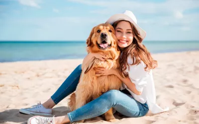 A la playa con tu perro Mujer en la playa con su perro
