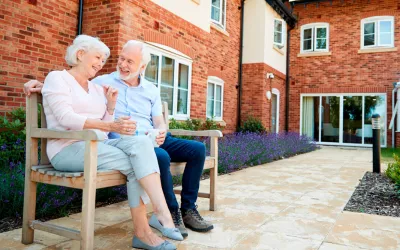 Senior cohousing, vivienda colaborativa para mayores Pareja de personas mayores junto a una vivienda colaborativa