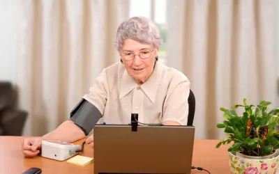 Telegeriatría Una anciana se toma la tensión en casa frente a la pantalla de un ordenador