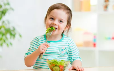 Trucos para que coman verduras Niña comiendo verdura