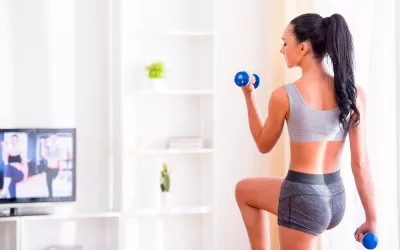 Tu gimnasio en casa Una mujer levanta pesas en su casa