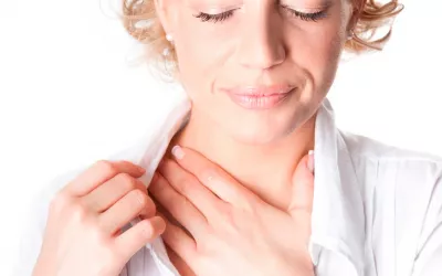 Qué es la tuberculosis Una mujer se toca el cuello con gesto de dolor