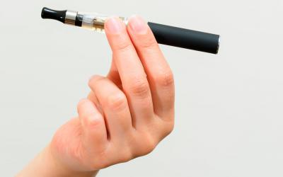 Persona sujetando un cigarro electrónico con la mano