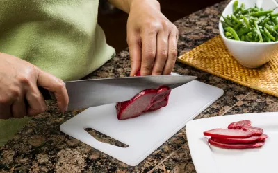 Persona usando una tabla de cortar alimentos