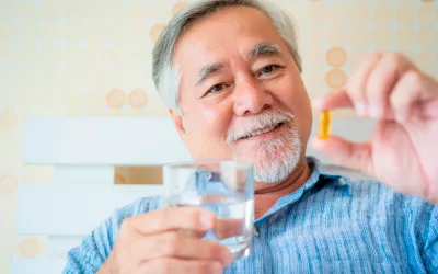 Anciano tomando cápsulas de omega 3 para prevenir las pérdidas de memoria