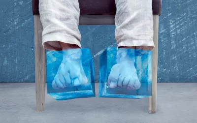 Pies siempre fríos: causas y consejos para evitarlo Una persona sentada con unas bolsas para congelar en los pies