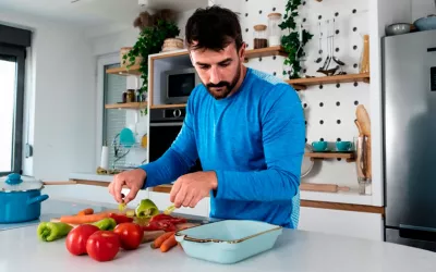 Hombre preparándose la comida a base de vegetales