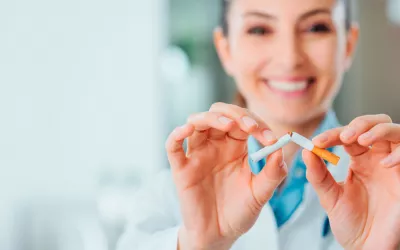 Doctora rompiendo un cigarro frente a un paciente adicto al tabaco