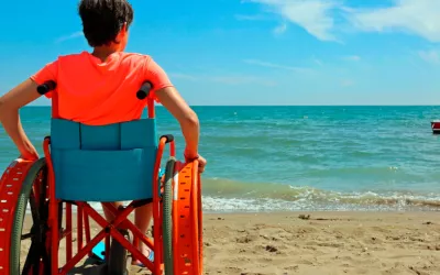 Joven en una silla de ruedas mirando al mar