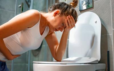 Mujer vomitando por la mañana en el baño