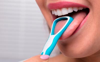 Mujer limpiando su lengua con un rascador