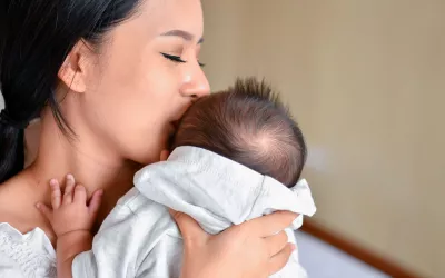 Madre abrazando a su bebé con síndrome de Menkes