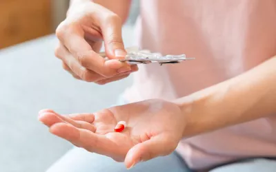 Mujer tomando un antigripal para combatir el catarro