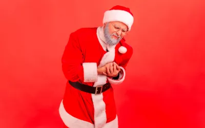 Hombre disfrazado de Santa Claus con dolor en el pecho