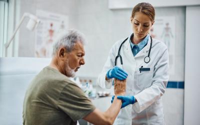 Doctor examinando a un anciano con dolor en la mano