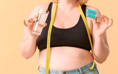 Mujer obesa tomando píldoras para adelgazar