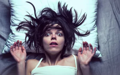 Onirofobia: cómo vencer el miedo a dormir Chica en la cama despertándose sobresaltada