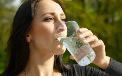 Mujer bebiendo un vaso de agua con gas