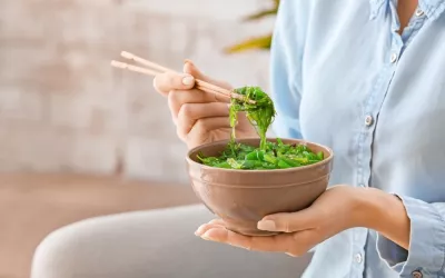 Mujer comiendo una ensalada de algas wakame