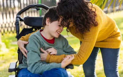Niño en silla de ruedas es atendido por su madre Mujer atiende a su hijo en silla de ruedas