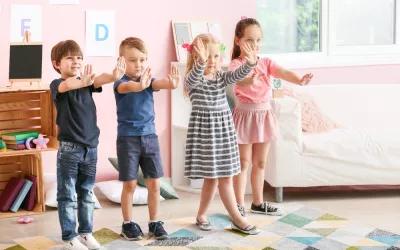 Niños pequeños en clase jugando al juego de la estatua