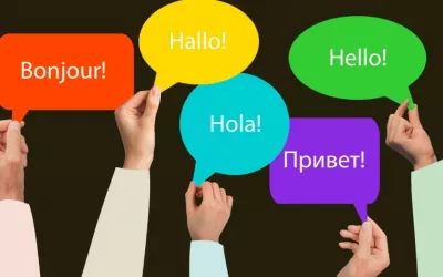 Manos sostienen carteles con la palabra hola en varios idiomas Varias manos sostienen carteles con un saludo en varios idiomas