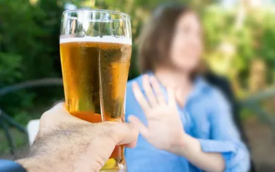 Mujer borrosa rechaza con la mano la cerveza que le ofrecen
