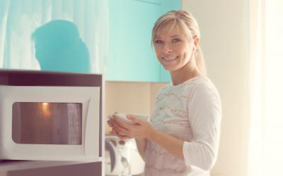 Mujer cocinando con el microondas