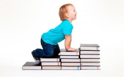 Niño apoyado sobre una escalera hecha con libros