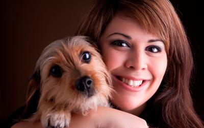 Una mujer posa sonriente con su perro en brazos