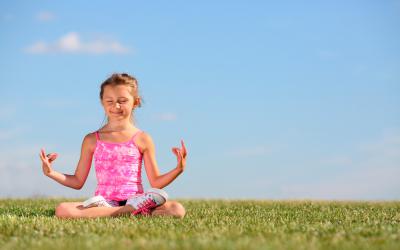 Niña haciendo yoga al aire libre