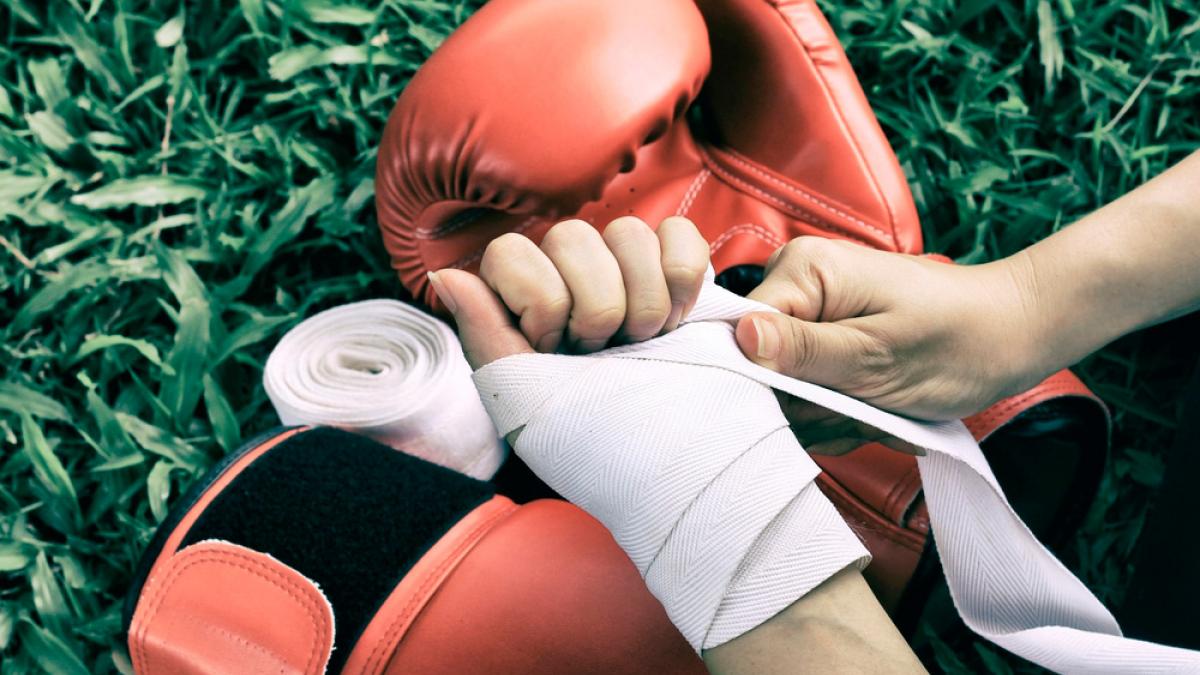 Mujer atractiva con guantes de boxeo listos para hacer ejercicio
